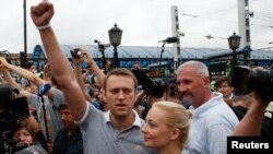 Pemimpin oposisi Rusia Alexei Navalny (kiri) memberikan sambutan di hadapan para pendukungnya yang menyambut kedatangannya dan istrinya, Yulia, dari Kirov di stasiun Moskow (20/7).