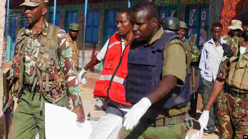 Polícia queniana carrega um corpo em Mandera, Quénia, Terça-feira, 7 de Julho, 2015.