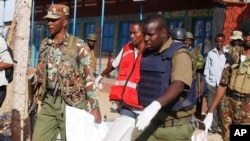 7일 아프리카 케냐 만데라에서 경찰이 무장괴한의 총기 난사로 사망한 희생자의 사체를 옮기고 있다. 