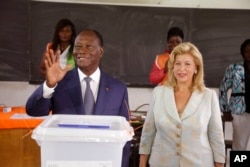 Đương kim Tổng thống Alassane Ouattara và vợ Dominique Ouattara, tại một trạm bỏ phiếu ở Abidjan, ngày 25/10/2015.