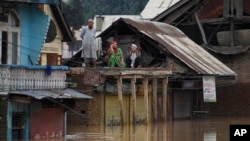 Flood-affected Kashmiris shout out for help from the roof of a house in Srinagar, India, Sept. 9, 2014. 