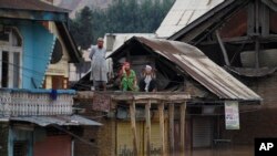 Flood-affected Kashmiris shout out for help from the roof of a house in Srinagar, India, Sept. 9, 2014. 