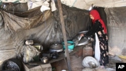 A refugee woman originally from the western Iraqi desert region, packs away pots and pans in her tent home several kilometers from the southern holy city of Karbala, some 110 kms from Baghdad (2009 file photo)