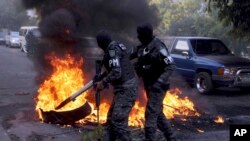 FILE - Military police clear a barricade set up by protesters supporting opposition presidential candidate Salvador Nasralla, in the outskirts of Tegucigalpa, Honduras, Dec. 22, 2017. 