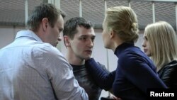 Lãnh tụ đối lập Nga Alexei Navalny và vợ Yulia an ủi em trai Oleg Navalny và vợ Victoria sau phán quyết của tòa án ở Moscow, ngày 30/12/2014. 