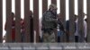 Seorang petugas Dinas Bea Cukai dan Perlindungan Perbatasan AS berjalan di sepanjang dinding perbatasan AS-Meksiko, tampak dari San Diego, California, 25 November 2018.
