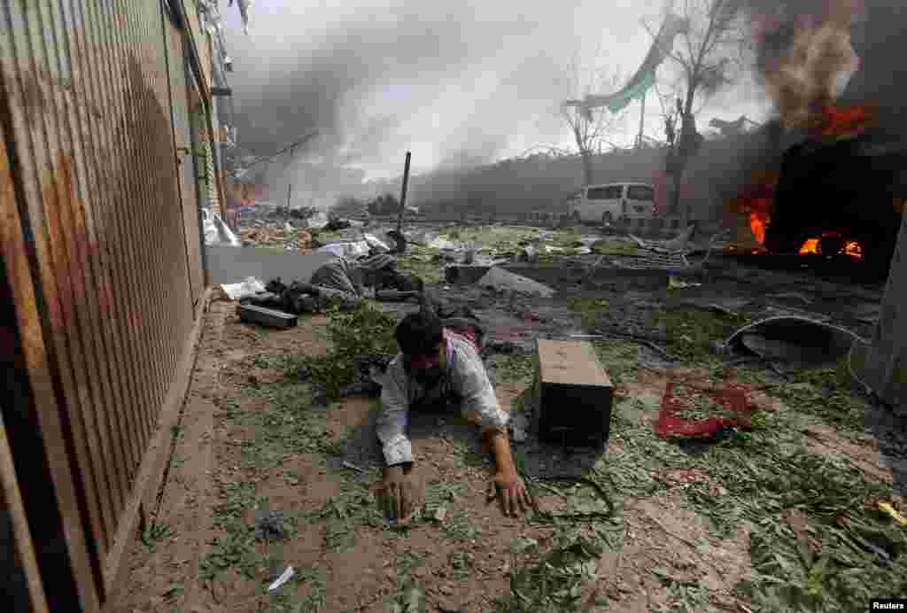 A wounded man lies on the ground at the site of a blast in Kabul, Afghanistan. A massive truck bomb exploded in the diplomatic section of the Afghanistan capital, killing at least 90 people and wounding more than 300 others.