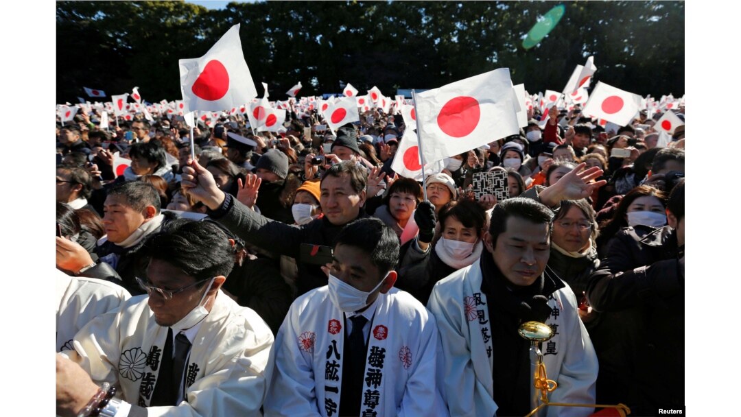 Warga Jepang melambaikan bendera Jepang dan meneriakkan “Banzai” saat Kaisar Jepang Akihito dan anggota keluarga kerajaan tampil dalam perayaan Tahun Baru di Istana Kekaisaran di Tokyo, Jepang, 2 Januari 2019.