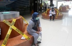 Para pengunjung di sebuah rumah sakit di Padang, Sumatra Barat, duduk berjauhan untuk mencegah penularan virus corona (COVID-19), 21 Maret 2020. (Foto: Antara via Reuters)
