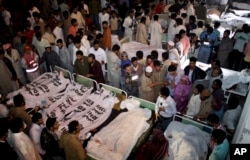 Pakistanis gather to identify bodies of their relatives killed in a bomb blast at a local hospital in Lahore, Pakistan, Nov. 2, 2014.