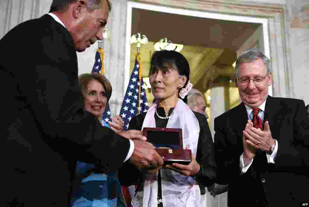 Burma's Aung San Suu Kyi (C) is presented with Congressional Gold Medal by Speaker of US House John Boehner as House Minority Leader Nancy Pelosi (2nd L) and Senate Minority Leader Sen. Mitch McConnell (R) look on Sept. 19, 2012