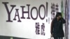 FILE - A woman walks past a Yahoo billboard in a Beijing subway station, March 17, 2006. Yahoo Inc. withdrew from the China market Nov. 1, 2021, because of an "increasingly challenging" business and legal environment.