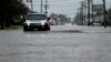 Cars drive through flooded streets in Lake Charles, La., as the city is hit with heavy rains from Tropical Storm Harvey, Aug. 27, 2017. The National Hurricane Center predicts a new tropical storm could form later this week, this time along the U.S. eastern seaboard.