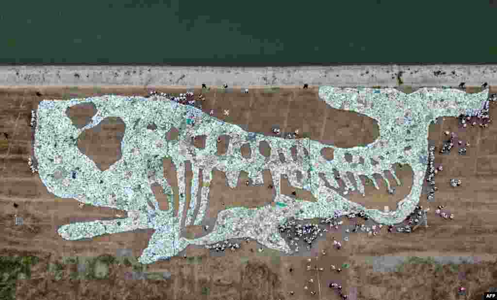 Foto udara menunjukkan gambar seekor paus sepanjang 68 meter yang terbentuk dari limbah plastik yang dikumpulkan dari samudra dalam sebuah acara untuk meningkatkan kesadaran tentang pelestarian samudra di Pelabuhan Rudong Yangkou di Nantong, di provinsi sebelah timur China, Jiangsu.