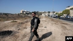 An Israeli border guard walks near the scene where a Palestinian man was killed after he attempted to stab a soldier in the east Jerusalem Jewish settlement of Armon Hanatsiv, adjacent to the Palestinian neighborhood of Jabal Mukaber, Oct. 17, 2015.