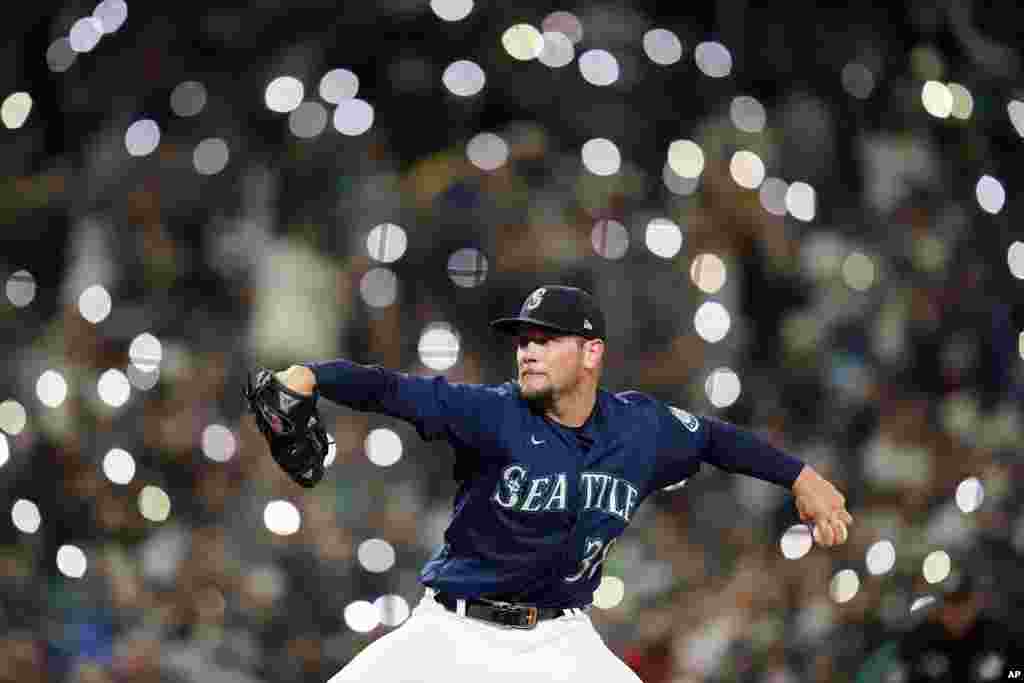 Cell phones light up the seats behind as Seattle Mariners relief pitcher Anthony Misiewicz throws against the Los Angeles Angels in the seventh inning of a baseball game, Oct. 2, 2021, in Seattle, Washington.