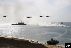 Russian navy ships and helicopters take a part in a landing operation during military drills at the Black Sea coast, Crimea, Sept. 9, 2016. The Russian military says major war games, the Zapad (West) 2017 maneuvers, set for next month will not threaten anyone.