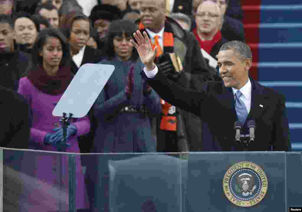 U.S. first lady Michelle Obama applauds and daughter Malia (L) looks on as U.S. President Barack Obama prepares to speak after he took the oath of office during swearing-in ceremonies on the West Front of the U.S. Capitol in Washington, January 21, 2013