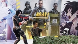 A child plays with a toy gun during a promotion for online games in Beijing on Saturday, Aug. 29, 2020. (AP Photo/Ng Han Guan)