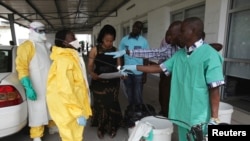 FILE - A health worker sprays a colleague with disinfectant during a training session for Congolese health workers to deal with Ebola virus in Kinshasa, Oct. 21, 2014. The Democratic Republic of Congo had declared a two-month ebola outbreak over. Ebola was recently confirmed in at least two people in the northwestern town of Bikoro. 