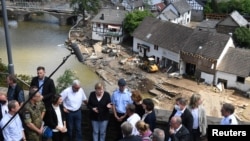 Kanselir Jerman Angela Merkel dan pemimpin negara bagian Rhineland-Palatinate, Malu Dreyer, berbincang dengan warga saat mengunjungi wilayah yang diterjang banjir di negara bagian itu, Minggu, 18 Juli 2021. (Foto: Christof Stache Pool/via Reuters)