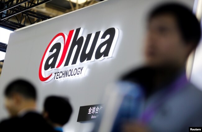 Visitors stand in front of a stall of the video surveillance product maker Dahua Technology at the Security China 2018 exhibition on public safety and security in Beijing, China Oct. 23, 2018.