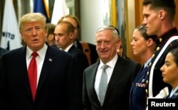 Secretary of Defense James Mattis, right, escorts U.S. President Donald Trump as he greets military personnel after attending a meeting at the Pentagon in Arlington, Virginia, July 20, 2017.