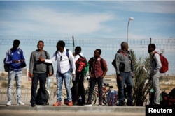 FILE - African migrants stand outside the Holot detention center in Israel's Negev desert, March 13, 2018.