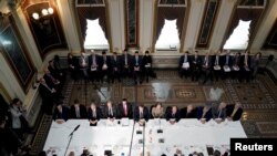 FILE - U.S. Trade Representative Robert Lighthizer, Treasury Secretary Steven Mnuchin, and other U.S. officials. with China's Vice Premier Liu He and other Chinese officials before the start of U.S.-China trade talks in Washington, Feb. 21, 2019. 