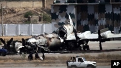 Pakistani troops drive past a wreckage of a gutted aircraft at Pakistan Navy base in Karachi, Pakistan, May 23, 2011