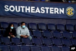 Fans wear masks and sit in marked-off seats at an NCAA college basketball game in the Southeastern Conference tournament Wednesday, March 10, 2021, in Nashville, Tenn.