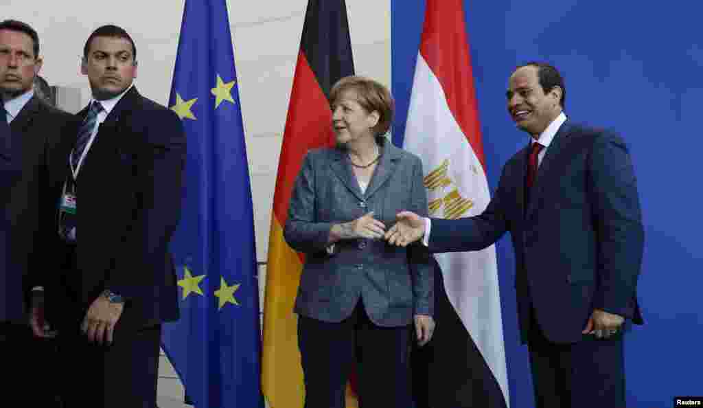 Guarda-costas da Chanceler alemã, Angela Merkel, observando a Chanceler e o Presidente do Egipto, Abdel Fattah el-Sissi que se cumprimentam na sequência de uma conferência de imprensa conjunta na chancelaria em Berlim, Alemanha. Junho 3, 2015 &nbsp;