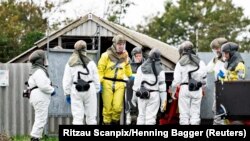 Employees from the Danish Veterinary and Food Administration and the Danish Emergency Management Agency in protective equipment are seen amid the coronavirus disease (COVID-19) outbreak at a mink farm in Gjoel, North Jutland, Denmark October 8, 2020.