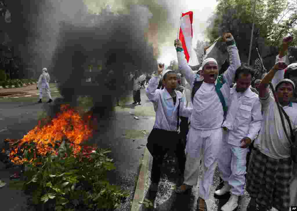 Muslim men shout slogans during a protest against American-made film "Innocence of Muslims" outside the US Embassy in Jakarta, Indonesia, Sept. 17, 2012.