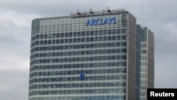 The letter 'B' of the signage on the Barclays headquarters in Canary Wharf is hoisted up the side of the building in London, July 20, 2012.