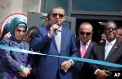 FILE - From left, Turkey's first lady Emine Erdogan, President Recep Tayyip Erdogan, Foreign Minister Mevlut Cavusoglu and Somali President Hassan Sheikh Mohamud at a new Turkish embassy in Mogadishu, Somalia, June 3, 2016.