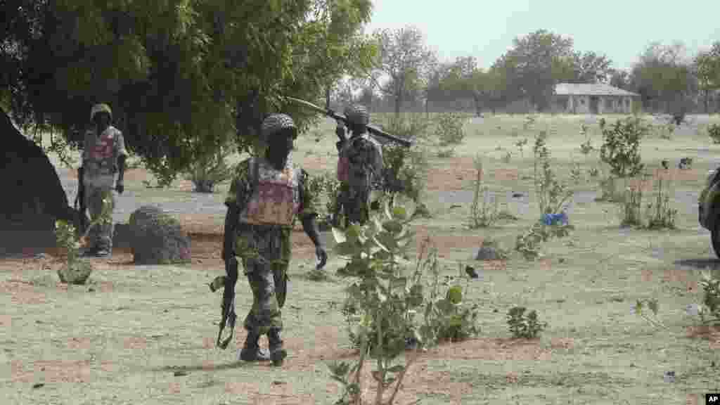 Soldiers walk through a village during a military patrol near Maiduguri.