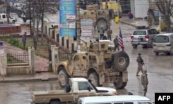 An image grab taken from a video obtained by AFPTV, Jan. 16, 2019, shows U.S. troops gathered at the scene of a suicide attack in the northern Syrian town of Manbij.