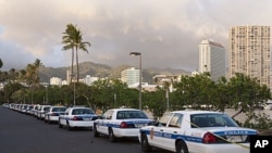 Honolulu police cars line the parking lot of Ala Moana Beach Park in Honolulu, November 8, 2011.