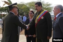 ປະທານາທິບໍດີເວເນຊູເອລາ ທ່ານ Nicolas Maduro, ຂວາ, ສຳພັດມືກັບ ລັດຖະມົນຕີປ້ອງກັນປະເທດ ເວເນຊູເອລາ ທ່ານ Vladimir Padrino Lopez.