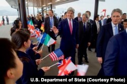 U.S. Secretary of State John Kerry greets school children as they arrive on Miyajima Island, Japan, as he and the other Group of Seven foreign ministers have a walking tour of the island amid the G-7 meetings, April 10, 2016.