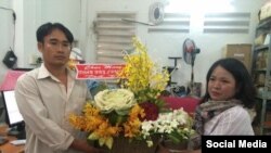 Đoàn Huy Chương (bên trái) nhận hoa chúc mừng từ Đỗ Thị Minh Hạnh, đại diện Phong Trào Lao động Việt, ngày 15/2/2017. (Facebook Phong Trào Lao động Việt).