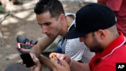 Internet users go online with their smartphones using the first public Wi-Fi hotspot in Havana, Cuba, July 2, 2015.