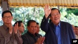 Cambodia's Prime Minister Hun Sen waves on his arrival for a groundbreaking ceremony for a bridge over the Tonle Sap river, at Russey Keo village near Phnom Penh, Cambodia, Monday, Oct. 23, 2017. (AP Photo/Heng Sinith)