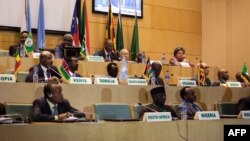 FILE - African Union Chairman Moussa Faki, second left at top, sits with members of the Intergovernmental Authority for Development as they attend a signing ceremony for a cease-fire agreement among South Sudanese parties to end the four-year war in the country, at the headquarters of African Union in the Ethiopian capital, Addis Ababa, Dec. 21, 2017. South Sudan peace talks were adjourned for several weeks on Feb. 16, 2018.