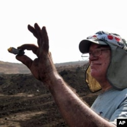 Paul Nascimbene holds up ancient amber found in India.