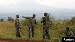 Soldiers from the Democratic Republic of Congo (DRC) rest near the town of Kibumba at its border with Rwanda after fighting broke out in the Eastern Congo town, June 11, 2014.