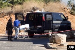 The body of a Palestinian is evacuated after he was killed during a raid by Israeli border police in a cemetery aimed at netting illegal immigrants in Petah Tikva, Nov. 30, 2013.