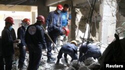 Rescue workers search for bodies still trapped under mounds of debris in Raqqa, Syria, Apr. 9, 2018. 