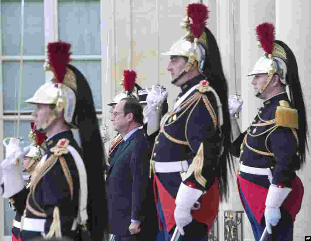 French President Francois Hollande, second left, looks toward Belgium&#39;s Prime Minister Charles Michel as he leaves the Elysee Palace in Paris after their meeting.